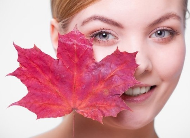 Женщина сидит с теплой чашкой, закутанная в плед